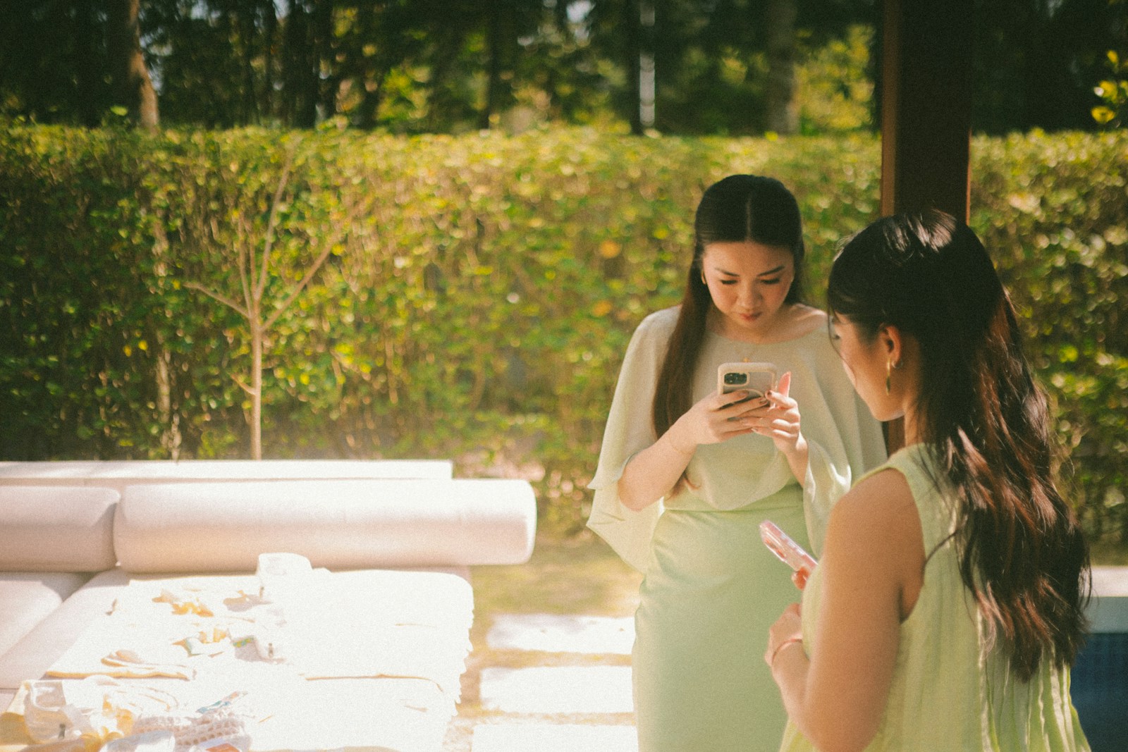 Two women looking at their phones outdoors