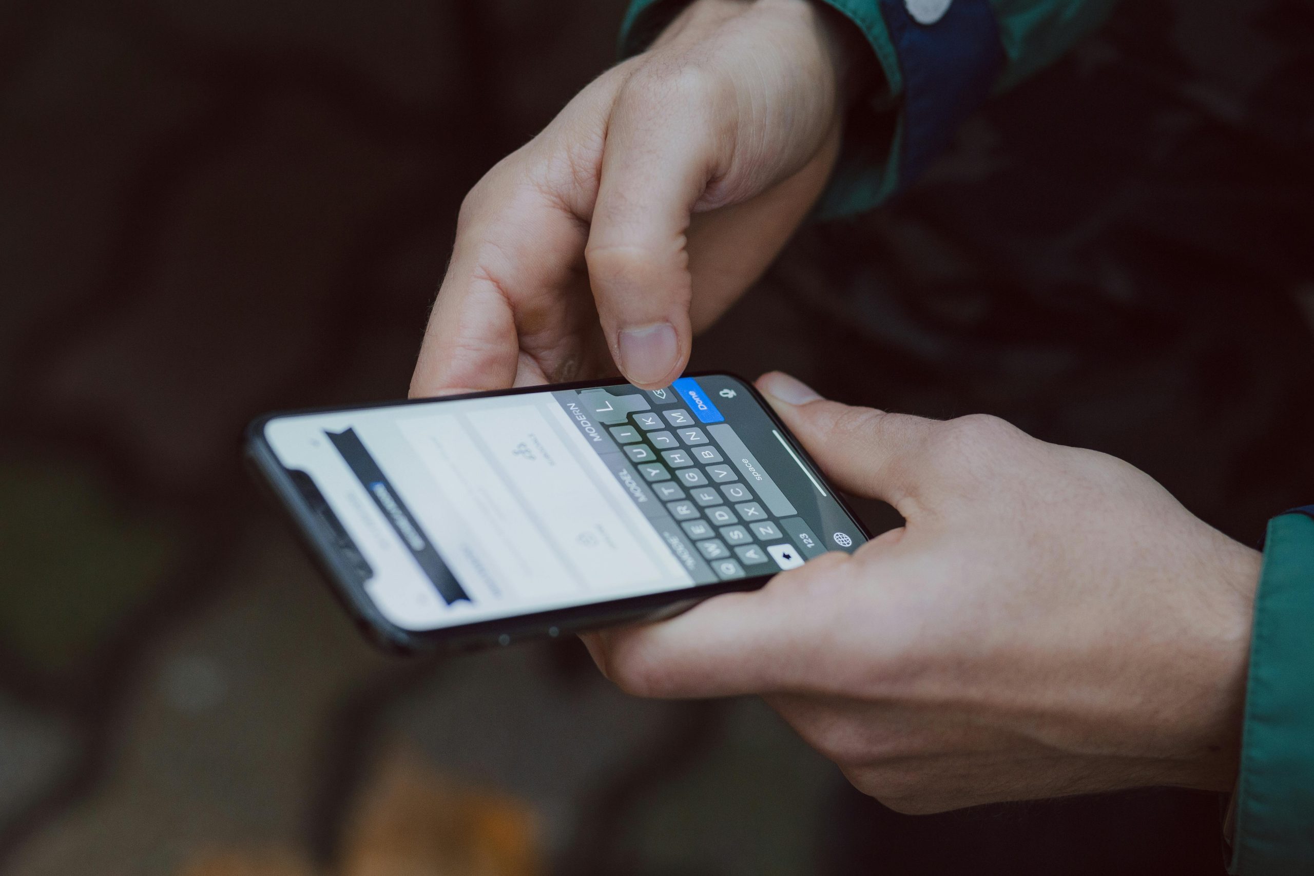 Close-up of person texting on a smartphone. Outdoor setting with wireless connectivity.